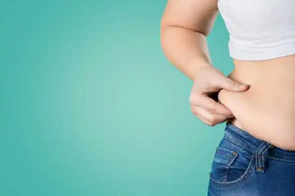 Image of woman pinching her love handles to show weight gain Richmond upon Thames