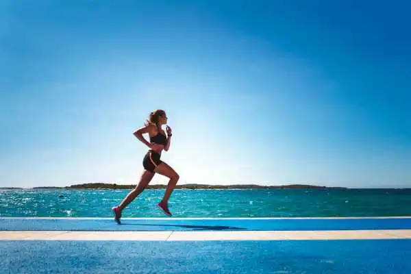Woman running showing strong leg muscle Richmond upon Thames